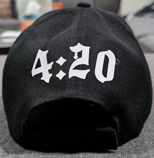 Black cap with '4:20' printed in white on a gray surface