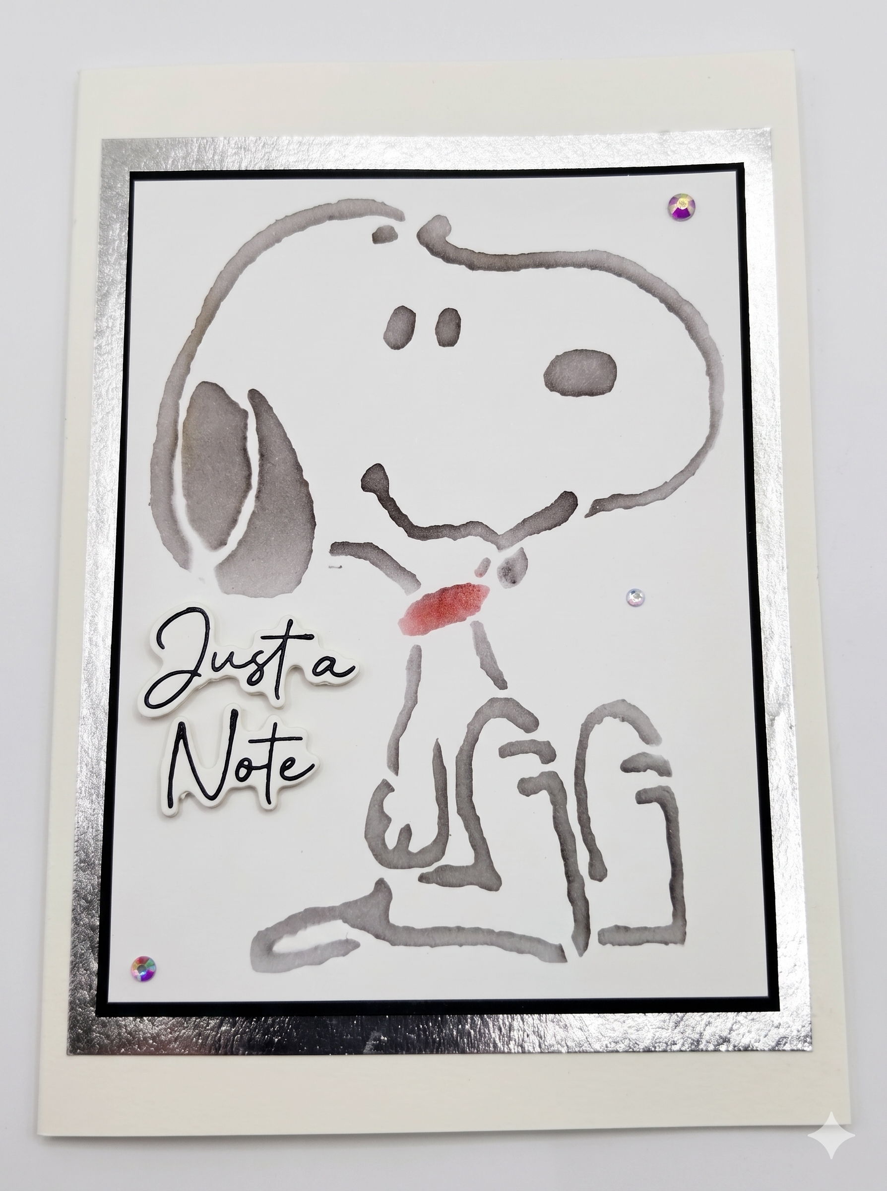A card with a water marked drawing of a cartoon dog with a message of "Just a Note" on the card.