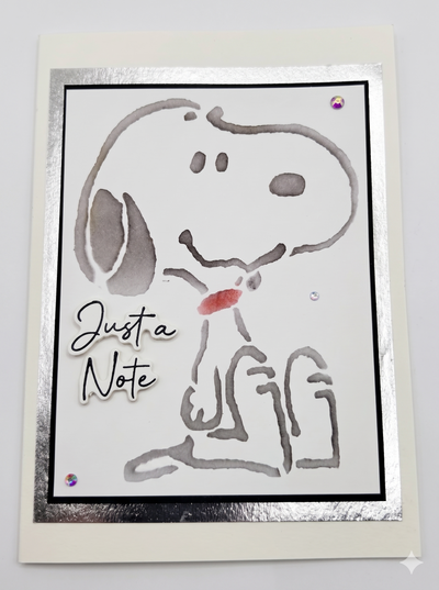 A card with a water marked drawing of a cartoon dog with a message of "Just a Note" on the card.