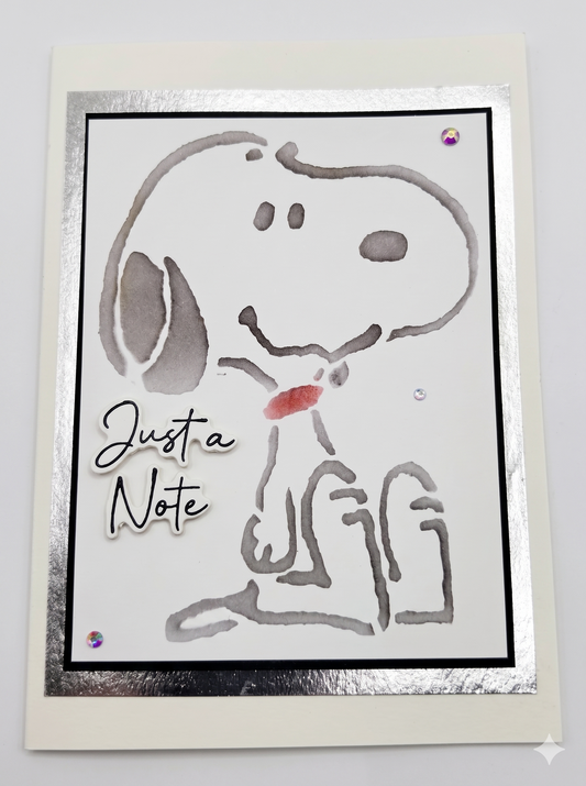 A card with a water marked drawing of a cartoon dog with a message of "Just a Note" on the card.