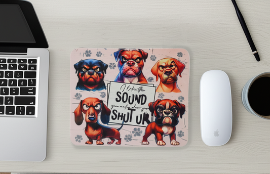 The image contains mouse pad decorated with an image of mad upset dogs. The mouse pad is on a desk with a laptop, mouse and coffee.